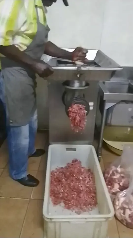 Mincing meat for boerewors on a commercial meat grinder